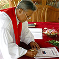  Priester unterschreibt die Heiratsurkunde 